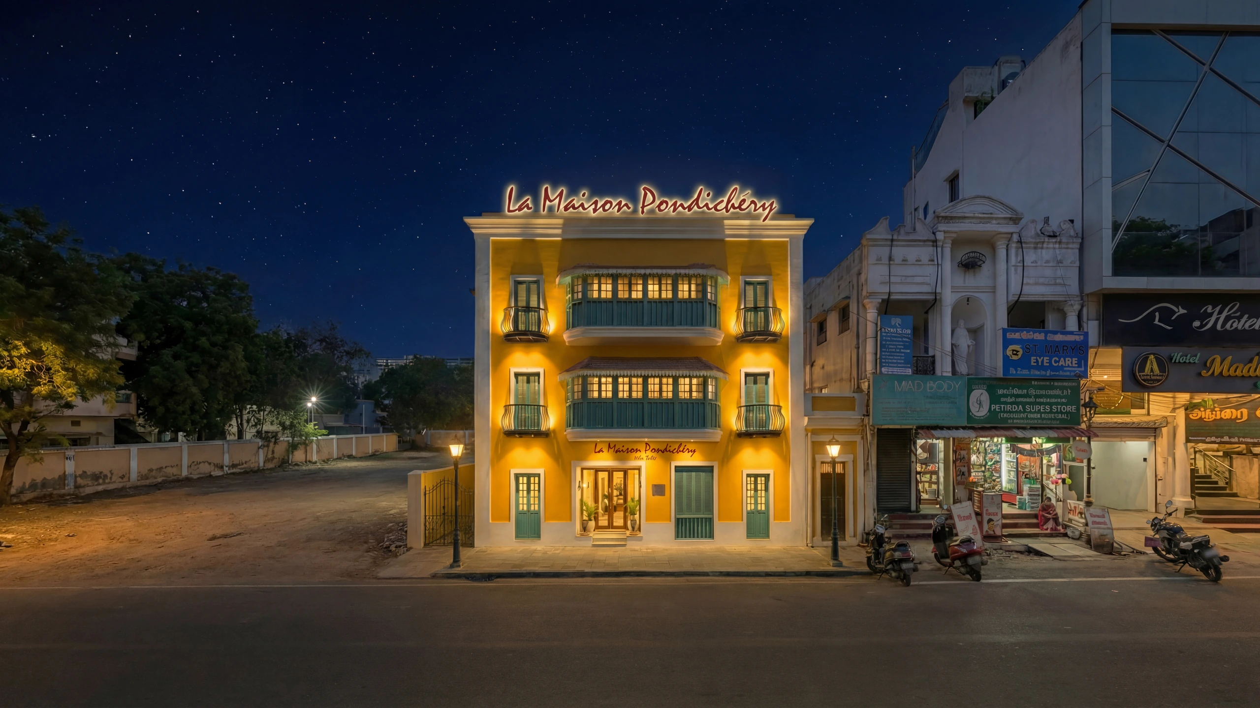 La Maison Pondichéry Heritage Building - Colonial architecture with mustard yellow facade, ornate balconies, and warm evening lighting